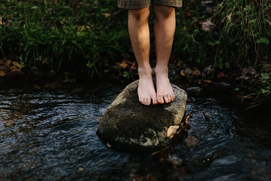 Man standing on stone with barefoot